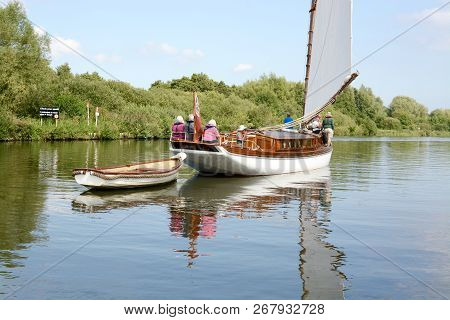 Norfolk, Uk - September 6,2018: Vintage Style Sail Boat Towing A Small Rowing Boat On The Norfolk Br