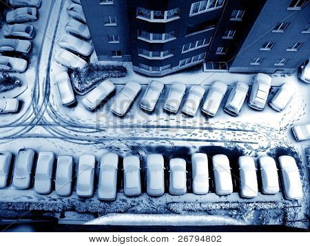 vista elevada de nieve cubre coches en parking y edificios de apartamentos