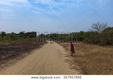 Orango Island, Guinea-bissau - February 3, 2018:  Young Boy Walking Along A Dirt Road Near The Villa