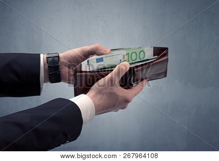 Businessman's hand in suit takes out eruo from his wallet