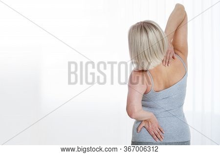 Middle Aged Woman In Pain Holding Her Backache