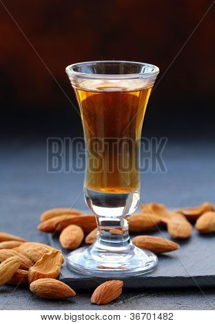 Amaretto mandlový likér s celých skořápkových plodů na tmavém pozadí