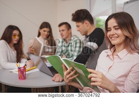 Close Up Of A Lovely Happy Young Female Student Smiling To The Camera Over Her Shoulder, Enjoying St