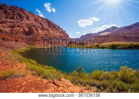 Smooth turn of the Colorado River. Steep river banks of red sandstone. Lee's Ferry is a historic boat ferry. Amazing wildlife. USA. The concept of active, extreme and photo tourism