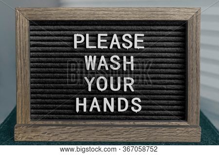 COVID-19 washing hands coronavirus spreading prevention message of handwashing hand hygiene corona virus text for washinghands.BLACK board sign with letters PLEASE WASH YOUR HANDS.