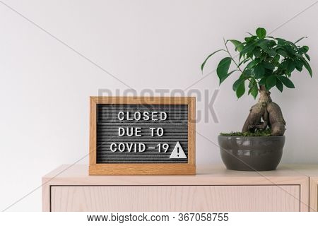 Closed business store due to COVID-19. Coronavirus lifestyle background with message sign at store front counter for closure of businesses and retail shops.