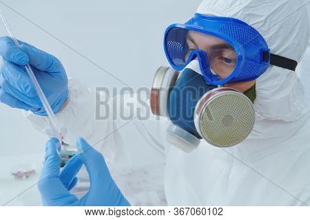 COVID-19. Doctor, microbiologist, scientist in a protective suit, makes a study of coronavirus in the laboratory. Coronavirus test.