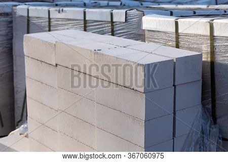 Silicate Brick On Wooden Pallets Wrapped In Transparent Plastic Wrap At A Construction Site
