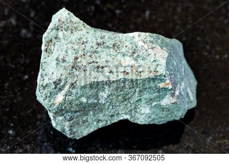 Closeup Of Sample Of Natural Mineral From Geological Collection - Unpolished Tinguaite Rock On Black