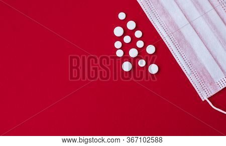 Medikal Mask And White Tablets On The Red Background