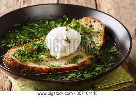 Light Portuguese Green Soup Acorda With Poached Bread And Egg Close-up In A Plate. Horizontal
