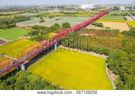 red famous Xilou Bridge over the river and farm in Yunlin county, Taiwan