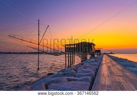 Traditional Fishing Station House With Fishnet In Water Of Adriatic Sea At Pier Diga Sottomarina, Sk