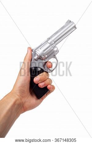 Hand Holding Up A Silver Revolver Pulling The Trigger, Gun In Hand Facing Up Symbol. Wild West Handg