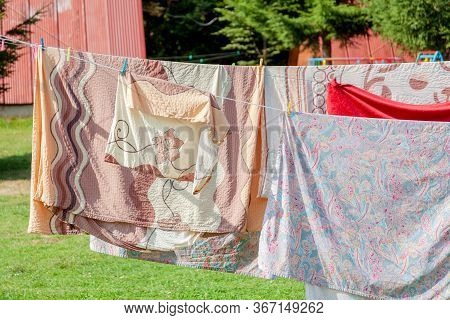 Simple Shot Of Laundry Hanging, Large Bed Set Bedding And Clothes Hanging On Wires On A Sunny Day, S