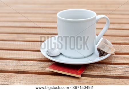Classy Traditional Simple Single White Teacup And A Silver Spoon Laying On A Natural Wooden Table Ba