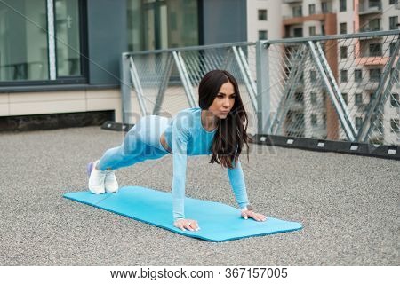 Woman doing workout alone on a roof
