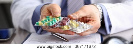 Gp In Clinic Holding Pack Of Different Blisters Close-up. Life Saving Medicament Prescribing Practic