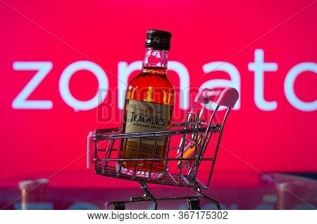 A Bottle Of Whiskey In A Trolley In Front Of A Zomato Board