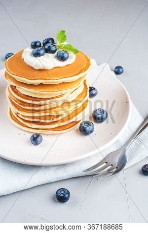A Stack Of Pancakes With Fresh Blueberries And Cheesecream.