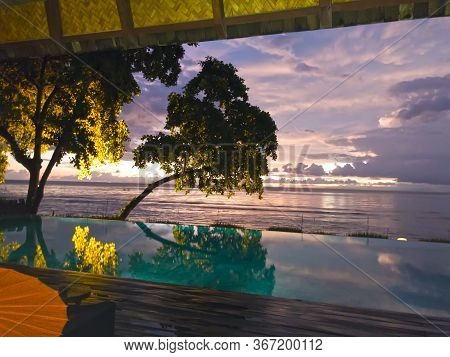 Lombok, Indonesia. Sunset Over The Sea On Senggigi Beach. View Through The Pool.