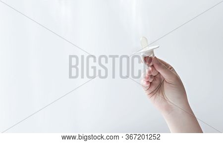 Young Womans Hand Holding Baby Pacifier. Mothers Hand Showing Baby Soother. Newborn Care Concept, Ki