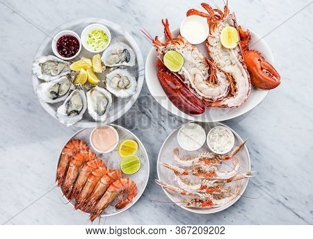 Mixed Fresh Seafood Platter Of Oysters, Lobster And King Prawns Placed On The Ice