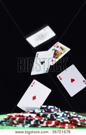 Giocando a carte che cade sulla pila di fiches per il gioco d'azzardo