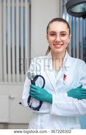 Portrait Of A Doctor Looking At The Camera. A Young Woman Is Smiling. Health Care, Medical. Combined