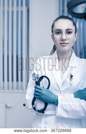 Portrait Of A Doctor Looking At The Camera. A Young Woman Is Smiling. Health Care, Medical. Combined