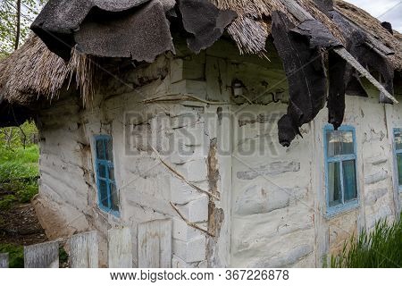 Old Vintage Rural House In Ukrainian Countryside Style. House With A Cattail Roof. The Roof Of The R