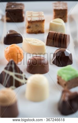 Mix Of Chocolates On A Table With Black Background, Confectioners Assortment Of Bon Bon Candies