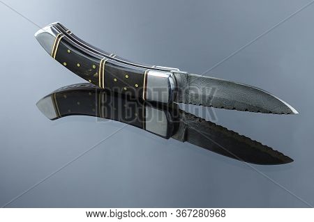 Folding Pocket Knife On A Mirrored Surface, Blade Made Of Multi-layer Damascus Steel, Handle Made Of