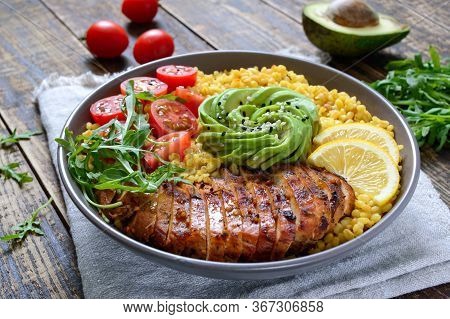 Bulgur With Grilled Chicken Breast, Fresh Vegetables, Avocado, Arugula. Diet Lunch On A Wooden Table