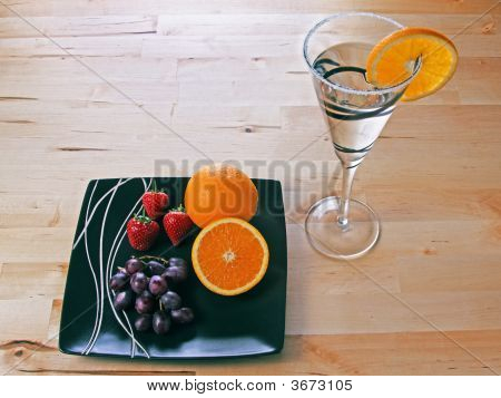 Cóctel con rodaja de naranja fresas y uvas