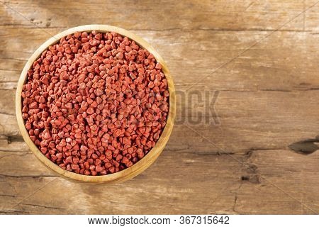 Organic Achiote Seeds - Bixa Orellana. Wood Background