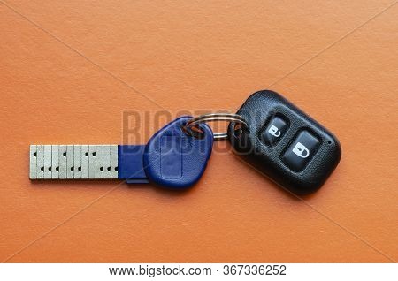 Chipped Door Key With Remote Control On An Orange Background