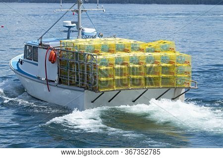 A Fishing Boat In The Waters Of Bar Harbor Maine Has Yellow Lobster Traps Staked Four High On A Full