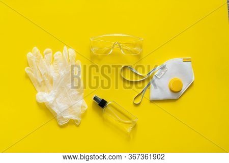 Respirator Ffp, Rubber Gloves, Antiseptic And Protective Glasses Lie On A Yellow Background. Anti-vi