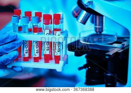 COVID-19 or SARS-CoV-2. Close-up of a microscope with Petri dish and coronavirus test. A scientist makes a study of coronavirus in the laboratory. Innovative technologies in medicine.