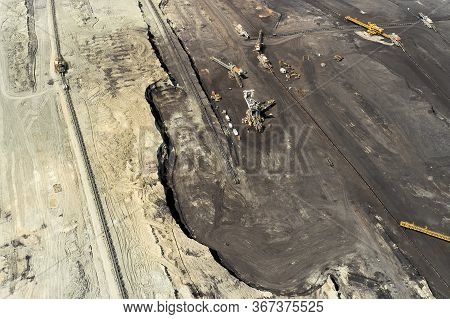 Top View Of A Mining Quarry With Huge Equipment For Coal Or Natural Raw Material Mining. Working Buc