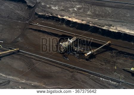 Top View Of A Mining Quarry With Huge Equipment For Coal Or Natural Raw Material Mining. Working Buc