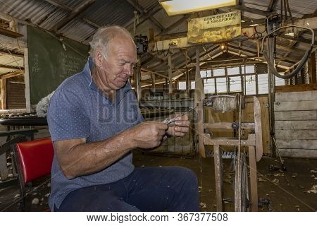 Kangaroo Island, Australia - March 9th, 2020: A Farmer Using A Spinning Wheel To Make Yarn Out Of Ra