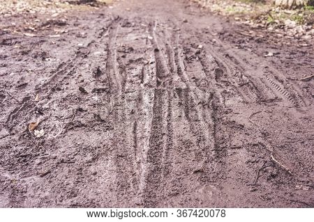 Boots And Bicycle Prints In The Mud
