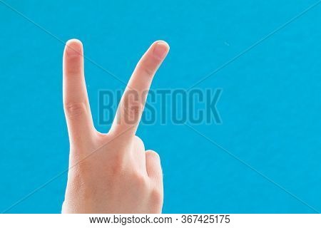 Close-up Hand With Two Fingers Up In A Symbol Of Peace Or Victory. Also A Sign For The Letter V In S
