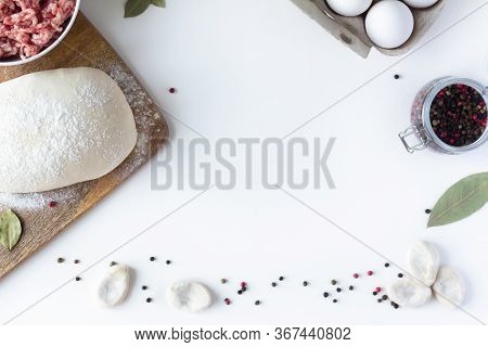 The Dough Lies On The Table, Next To Minced Meat, Eggs, Flour. White Background. Dumplings, Russian 