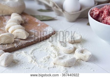 The Dough, Cut Into Pieces, Lies On A Table In Flour. Near The Minced Meat. Dumplings, Russian Cuisi