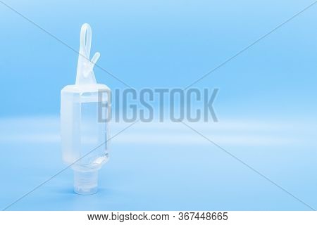 Clear Hand Sanitizer Keychain Isolated On A Blue Background.