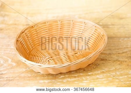 Oval Shaped Wicker Basket On A Wooden Table