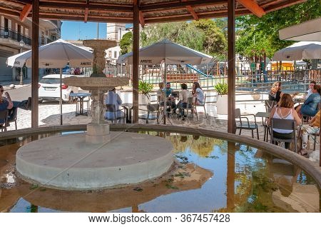 Sineu, Balearic Islands/spain; May/20/2020: Fountain And Terrace Of A Cafeteria In The Town Of Sineu